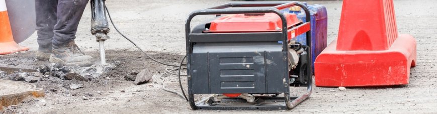 Muncitor alimenteaza un ciocan demolator de la un generator intr-o zona turistica